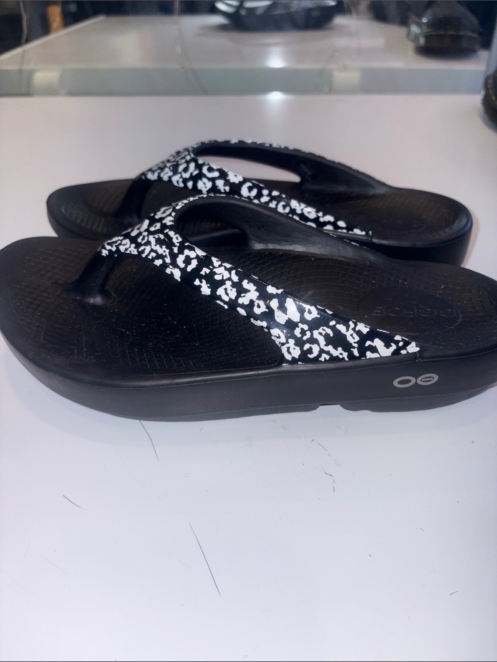 OOFOS Black Flip Flop Sandals with White Leopard-Print Straps